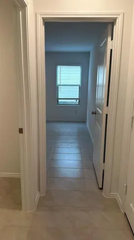 a view of a hallway with wooden floor and closet