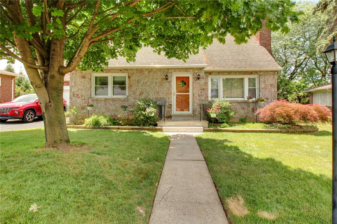 1256 Ridge Avenue Whitehall, PA 18052 - Photo 1 of 43 A charming stone facade home, nestled under mature trees, welcomes with a neatly paved walkway and vibrant landscaping.