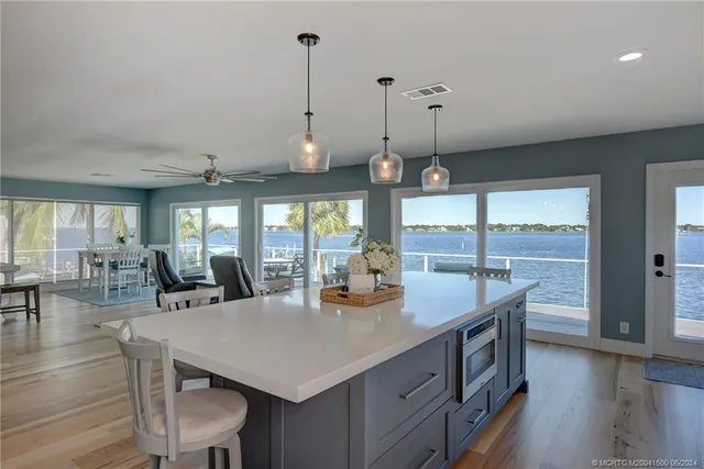 a view of a dining room and livingroom with furniture wooden floor a chandelier