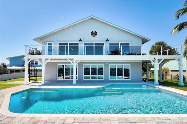 a view of a swimming pool with a yard and sitting area