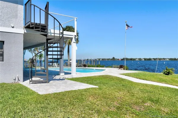a view of a house with swimming pool and a yard