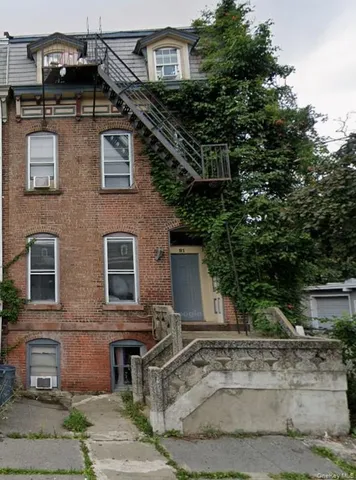 a front view of a house with shrubs
