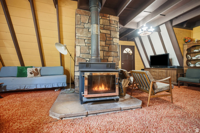 8505 South Snake Crk Road Salt Lake City, UT 84121 - Photo 10 of 67 Central stone-clad fireplace with a wood-burning stove and stone hearth
