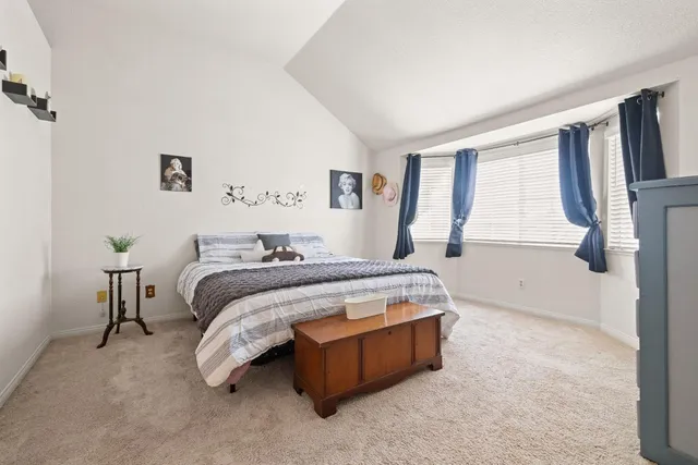 a bedroom with a bed lamp and a large window