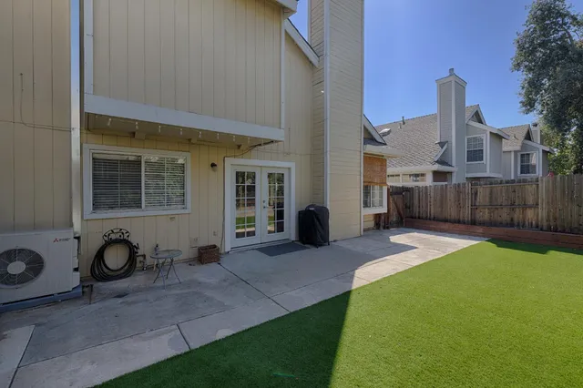 a view of a house with a patio and a yard