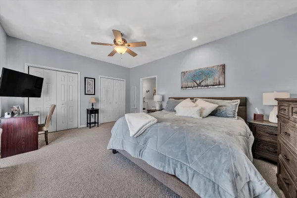 a spacious bedroom with a bed and a flat screen tv