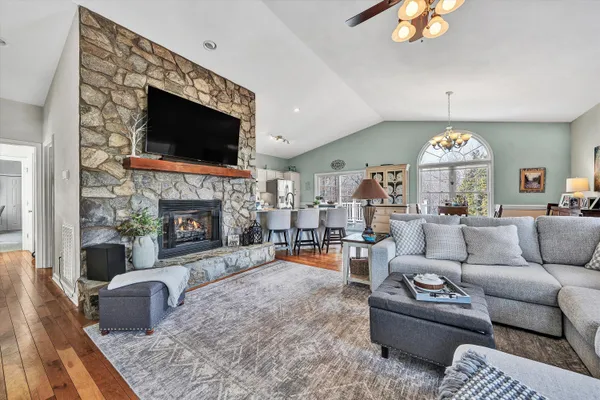 a living room with furniture a flat screen tv and a fireplace