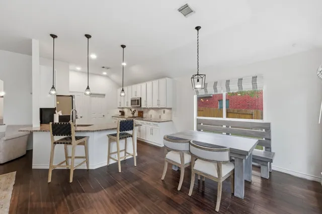 a dining room with furniture a chandelier and wooden floor