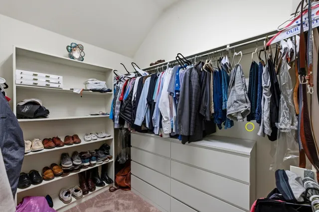 a view of walk in closet with clothes and shoes