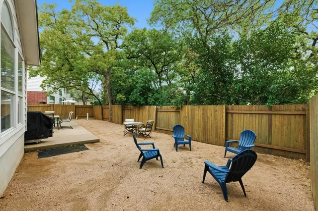 a view of a backyard with chairs and a fire pit