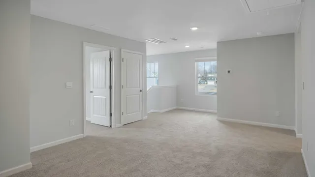 an empty room with closet and windows