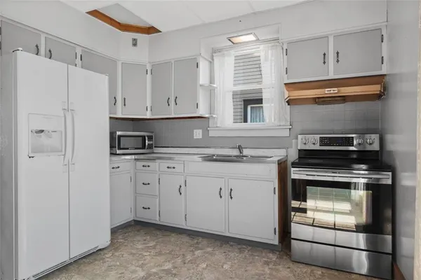 a kitchen with granite countertop cabinets stainless steel appliances and a sink