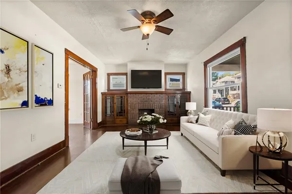 a living room with furniture fireplace and a large window