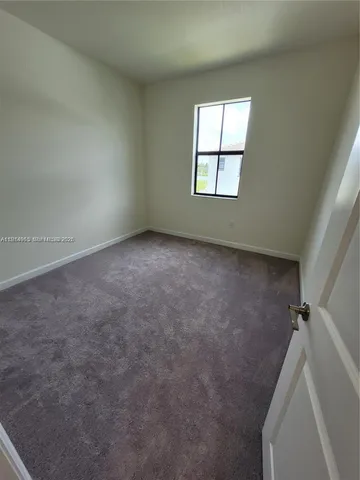 an empty room with an entrance to other room