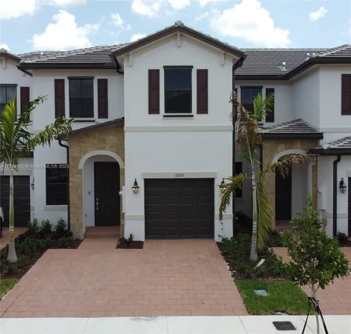 a front view of a house with a yard and garage