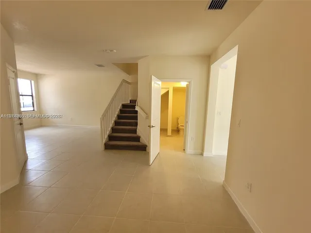 a view of a hallway with entryway and stairs