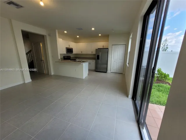 a view of a kitchen with a sink and a refrigerator