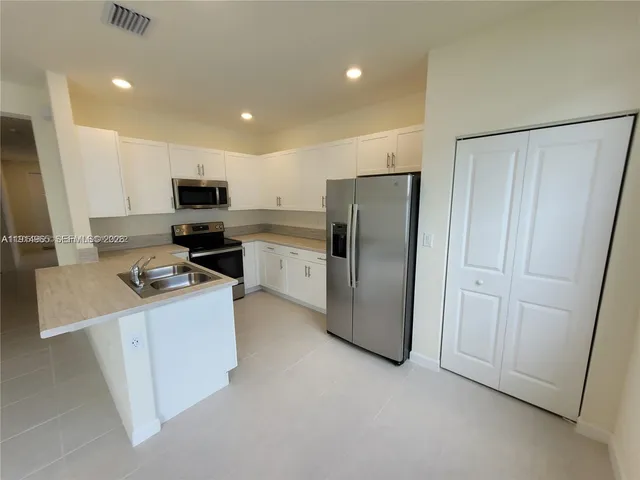 a kitchen with stainless steel appliances a refrigerator stove microwave and sink