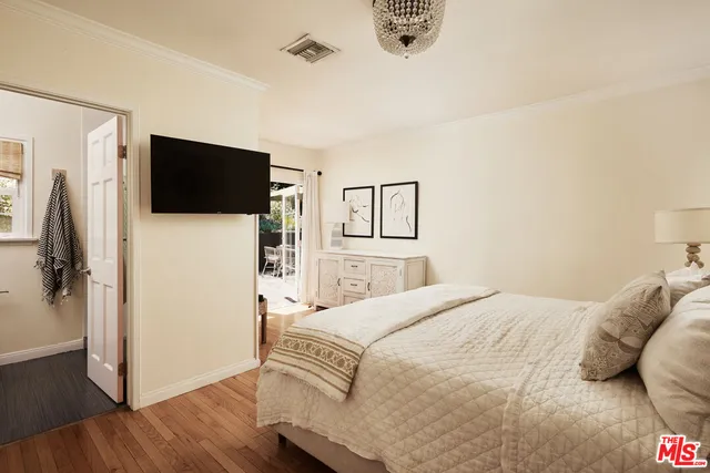 a bedroom with a bed a flat screen tv and a mirror