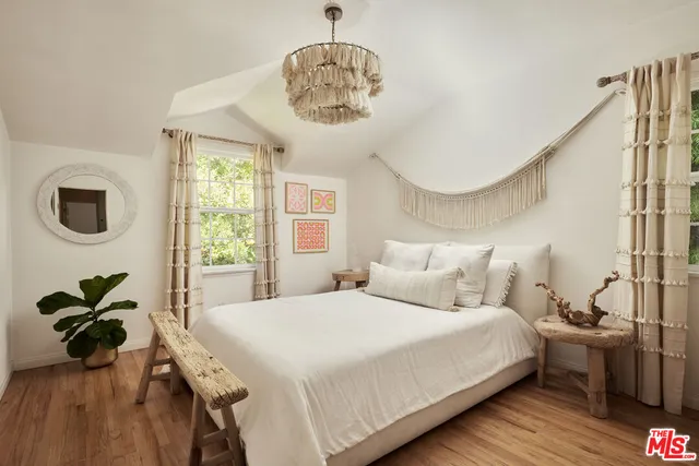 a bedroom with a bed mirror and window