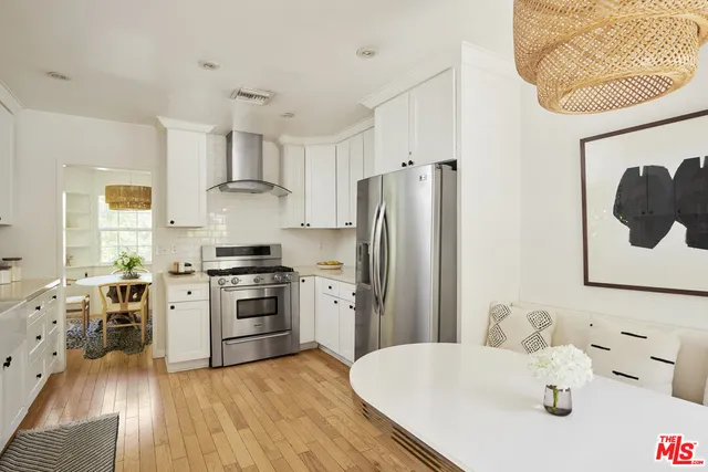 a kitchen with stainless steel appliances granite countertop a refrigerator a stove and a wooden floors