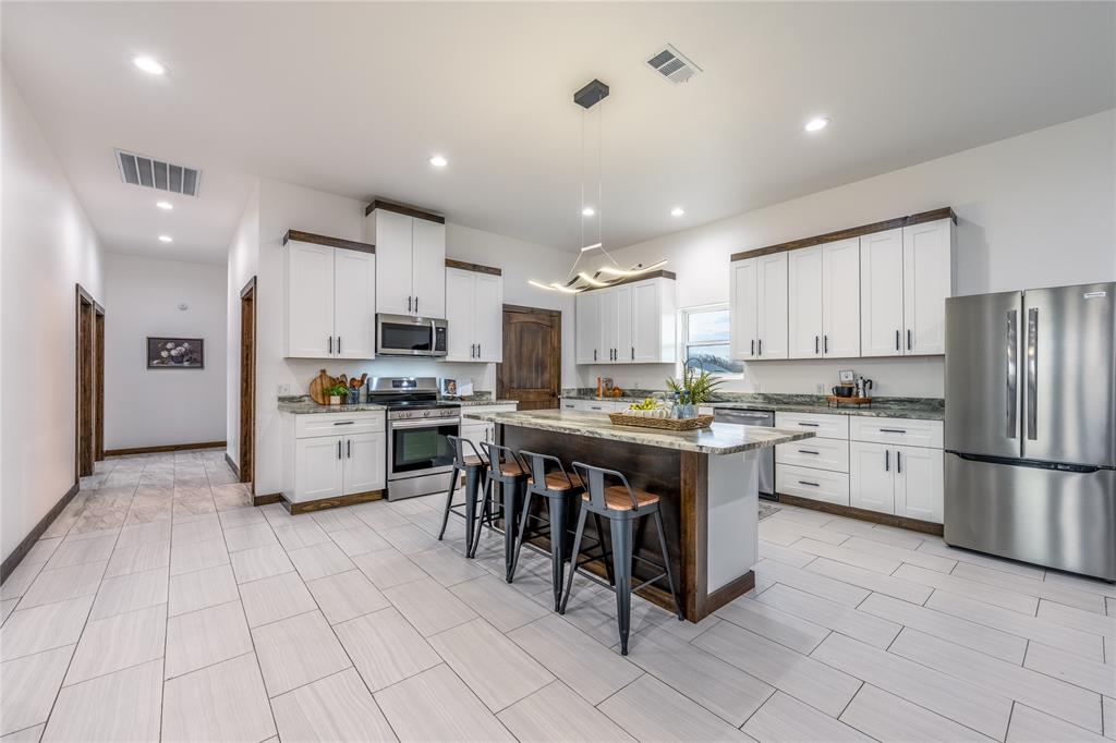 1706 County Road Sumner, TX 75486 - Photo 11 of 28 a kitchen with white cabinets and stainless steel appliances