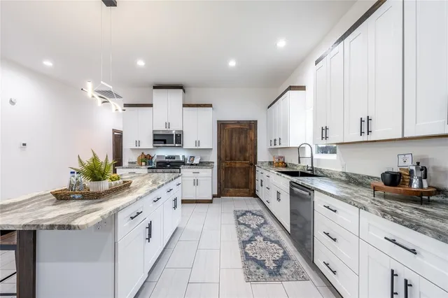 a kitchen with granite countertop kitchen island white cabinets and white appliances