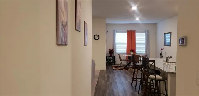 a kitchen with granite countertop a stove top oven a sink a dining table and chairs