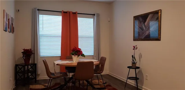 a living room with stainless steel appliances kitchen island granite countertop wooden floor and cabinets