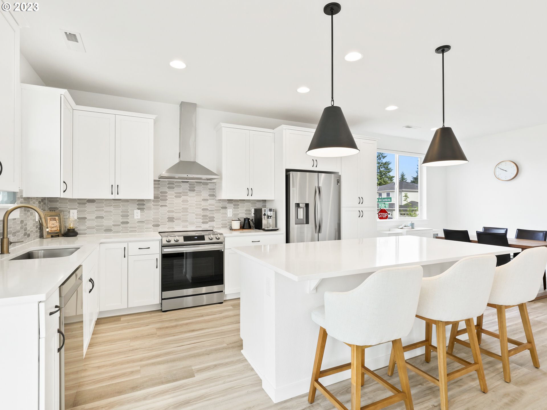 3005 North Mccanta Way Ridgefield, WA 98642 - Photo 11 of 37 a kitchen with stainless steel appliances kitchen island granite countertop a stove a sink and white cabinets with wooden floor