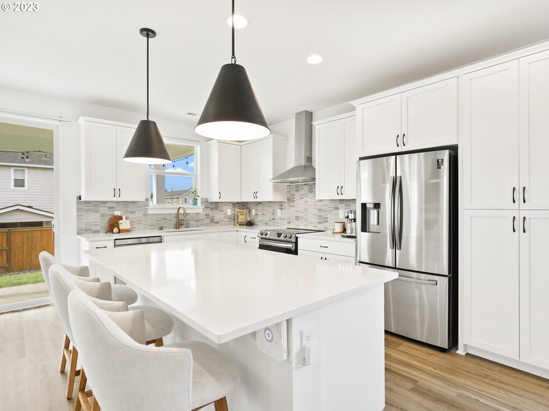 3005 North Mccanta Way Ridgefield, WA 98642 - Photo 8 of 37 a kitchen with stainless steel appliances granite countertop a sink a stove a refrigerator and island with wooden floor