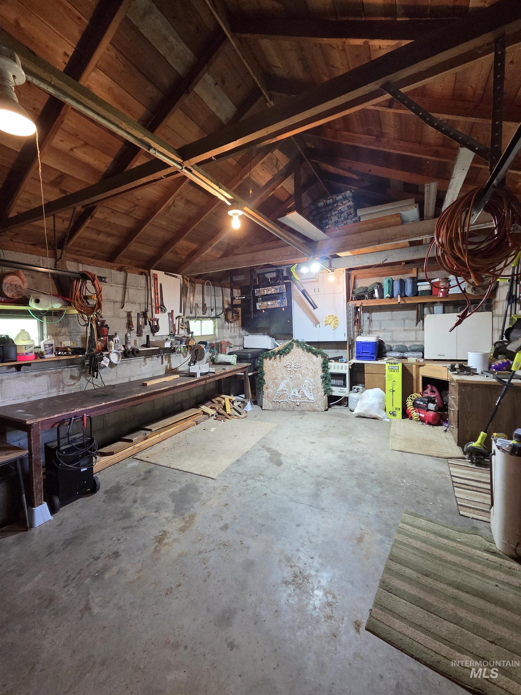 109 South 3rd Street Pomeroy, WA 99347 - Photo 29 of 36 Spacious workshop area featuring a concrete floor, exposed wood beam ceiling, and ample built-in shelving