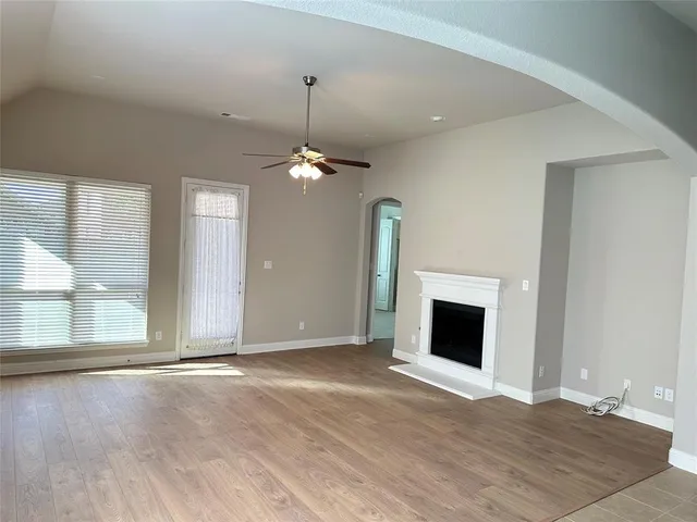 an empty room with fireplace and windows