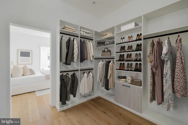 a view of walk in closet with clothes and shoes