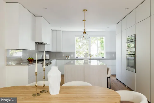 a kitchen with stainless steel appliances granite countertop a refrigerator a sink dishwasher a stove white cabinets and wooden floor