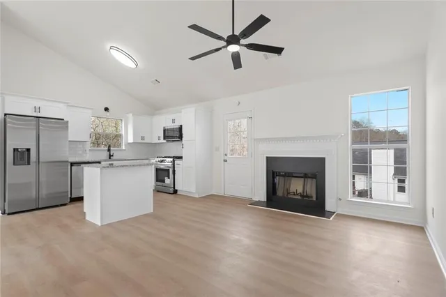 a view of kitchen with granite countertop cabinets and refrigerator