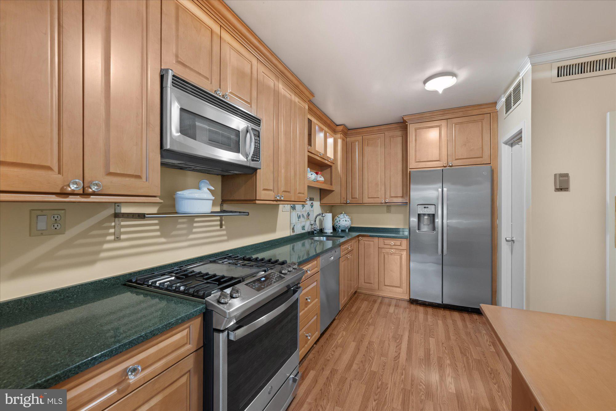 4100 Cathedral Avenue Northwest, Unit 717 Washington, DC 20016 - Photo 16 of 34 a kitchen with stainless steel appliances granite countertop a stove and a refrigerator