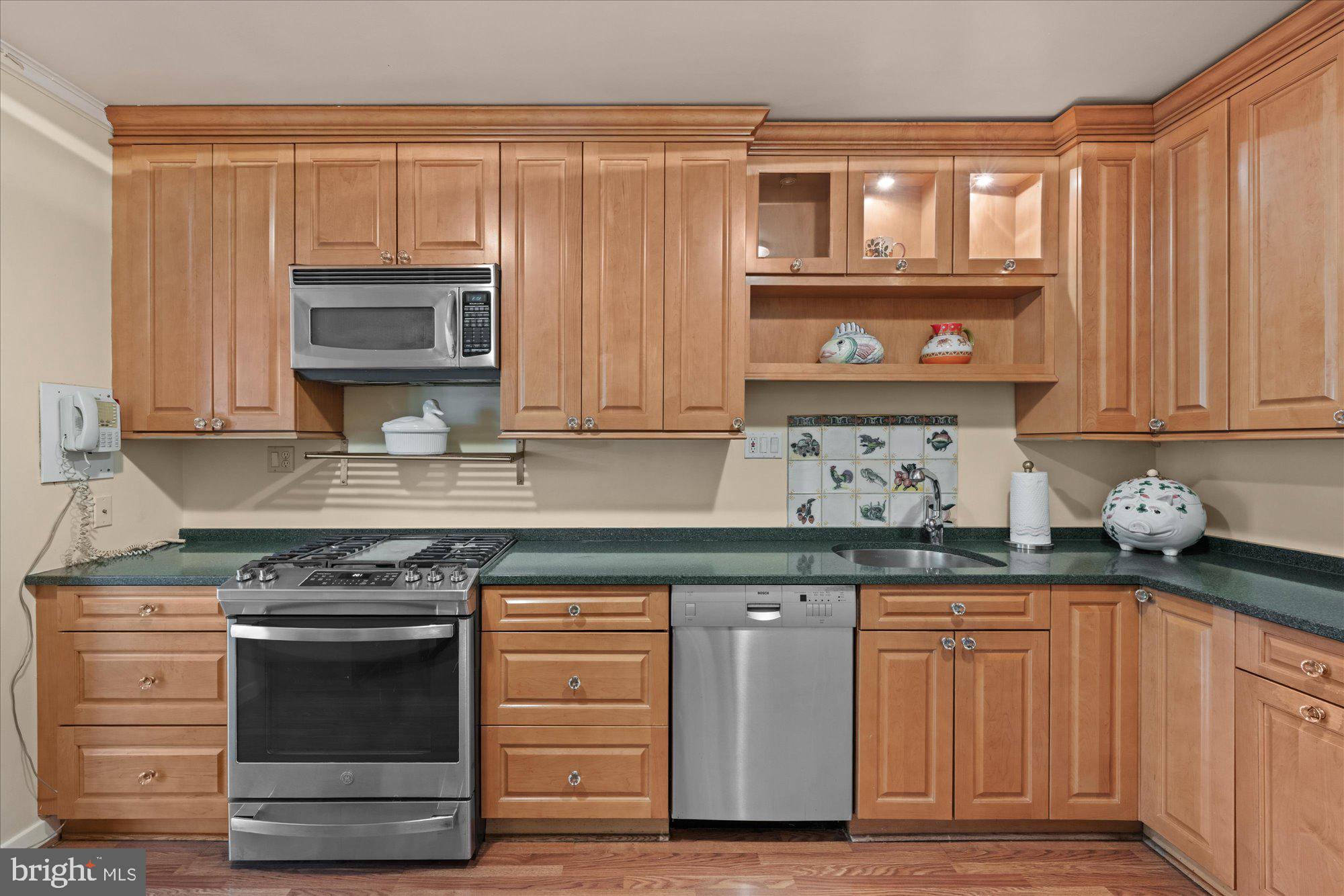 4100 Cathedral Avenue Northwest, Unit 717 Washington, DC 20016 - Photo 17 of 34 a kitchen with granite countertop a stove and cabinets