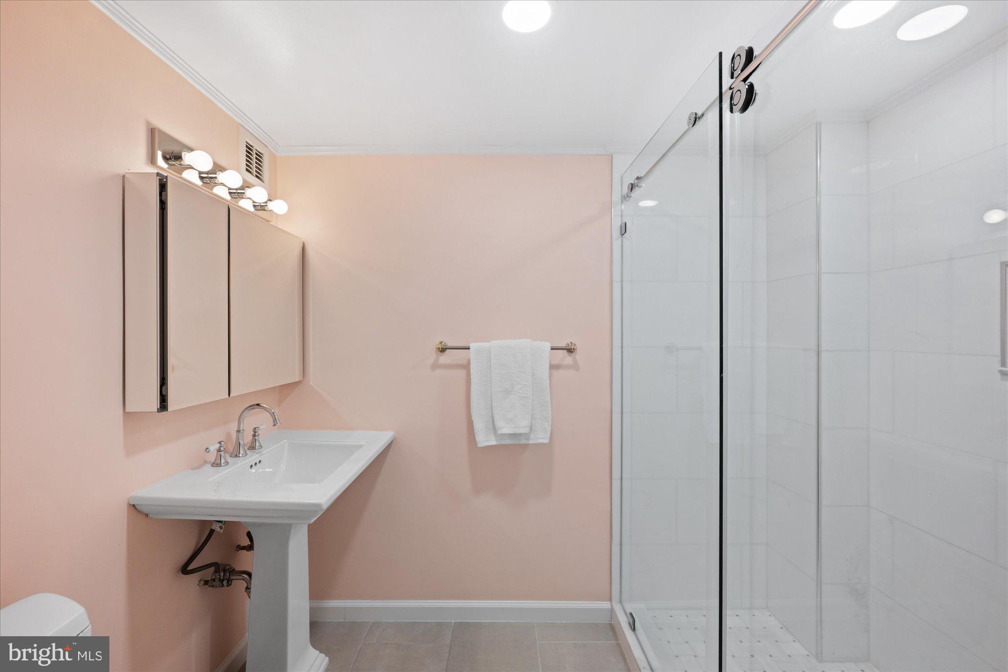 4100 Cathedral Avenue Northwest, Unit 717 Washington, DC 20016 - Photo 27 of 34 a bathroom with a sink a mirror a bathtub and shower