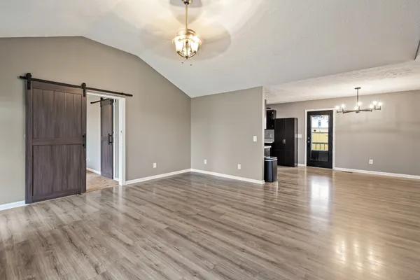 a view of an empty room with wooden floor