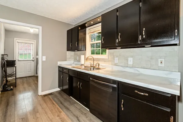 a kitchen with a sink and wooden floor