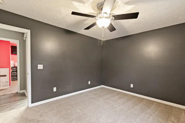 en empty room with windows and fan