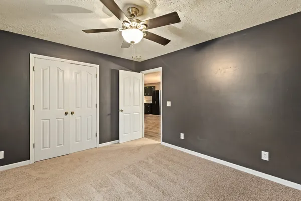 en empty room with fan and a ceiling fan