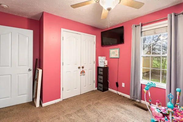 a view of an empty room with a window and a ceiling fan