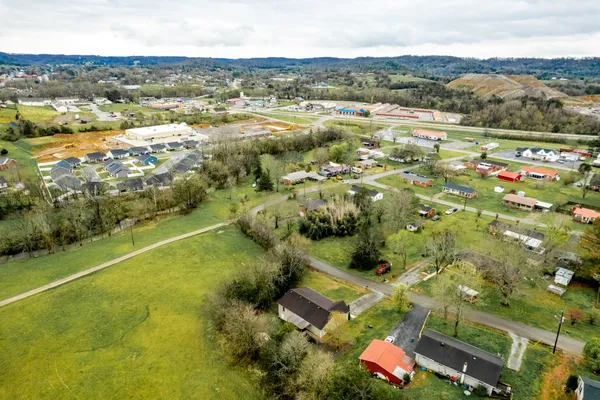 an aerial view of residential houses with outdoor space and trees