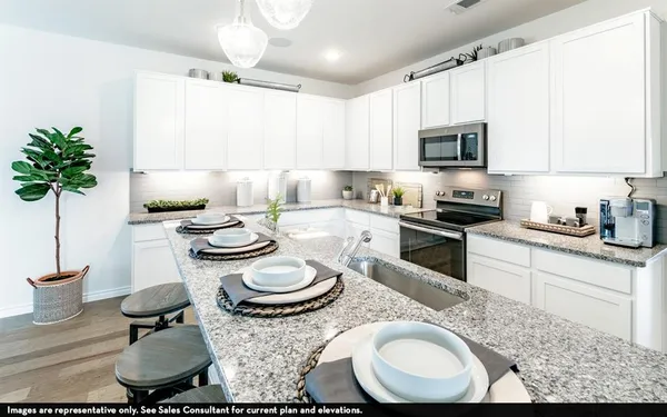 a kitchen with sink a stove and chairs