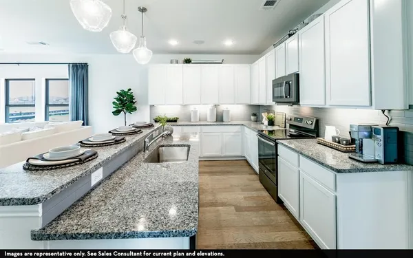 a large white kitchen with lots of counter space and stainless steel appliances