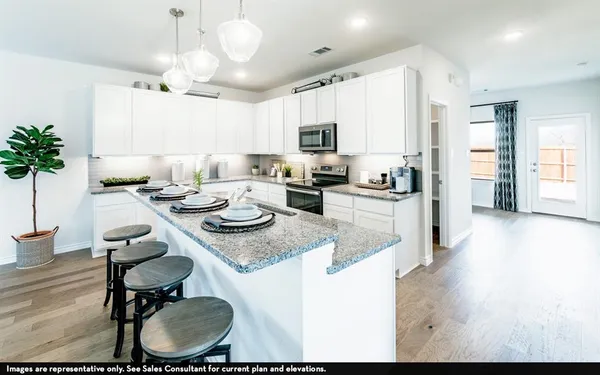 a kitchen with sink refrigerator dining table and chairs