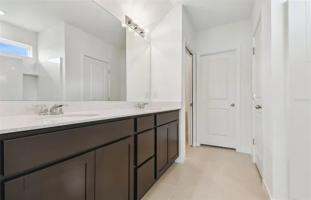 a bathroom with double sink and a mirror