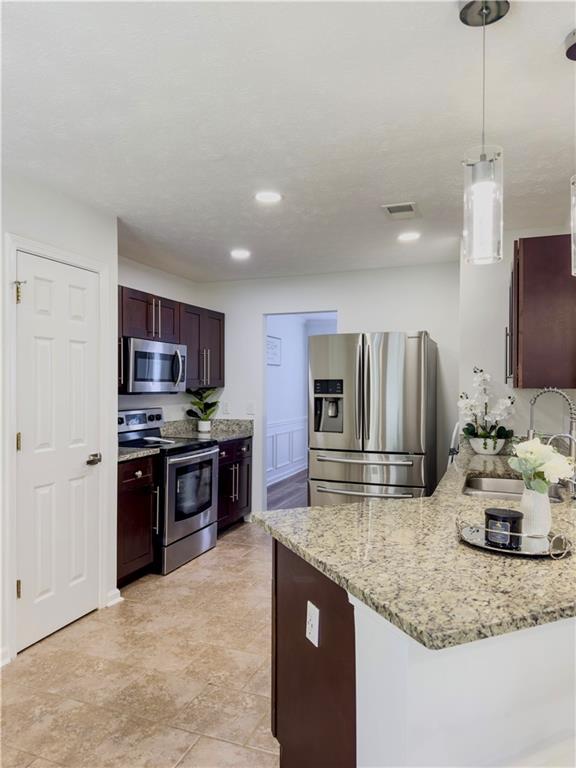 1559 Woodmore Road Southwest Marietta, GA 30008 - Photo 17 of 43 a kitchen with stainless steel appliances granite countertop a sink stove and refrigerator